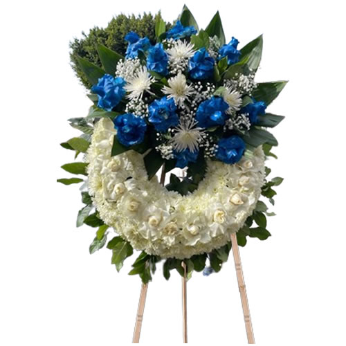 White rose wreath around, bouquet on top with blue rose, white spider, baby breath and lemon leaf around