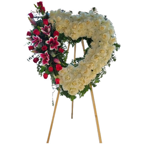 Large heart filled with white roses with a bouquet next to red roses and stargazer lilies