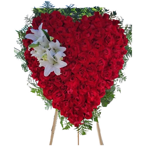 Large heart filled with red roses with a bouquet of white lilies