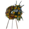 Large wreath with mixed flowers with a bouquet next to it with mixed colors of yellow and red